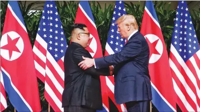  ?? The Straits Times/xinhua/zuma Press/tns ?? Top leader of North Korea Kim Jong Un, left, shakes hands with U.S. President Donald Trump in Singapore before today’s first-ever North Korea-u.s. summit.