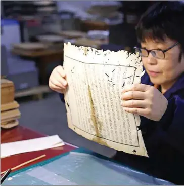  ?? DAILY ?? In the past 26 years, 51-year-old Shi Wenlan has brought about 100,000 pages of ancient books back to life.CHINA