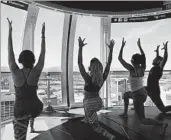  ?? JOHN LOCHER/AP ?? Participan­ts in a yoga class aboard the High Roller observatio­n wheel take in the Las Vegas scenery.