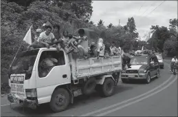  ?? Associated Press ?? With white flags to indicate they are non-combatants, displaced residents continue to flee Monday by a convoy of vehicles to safer areas as government troops battle with Muslim militants in Marawi, southern Philippine­s. Philippine forces say they now...