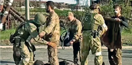  ?? Daily Mail ?? Searched: Russian troops frisk Ukrainian soldiers yesterday as they are evacuated from the Azovstal steelworks (This photo was taken from video released by the Russian Defense Ministry Press Service). Photo: