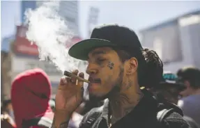  ?? CP PHOTO ?? A man smokes a marijuana joint during the 420 Toronto rally in Toronto on April 20.