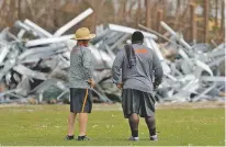  ?? GERALD HERBERT/ASSOCIATED PRESS ?? Mosley High defensive coordinato­r Danny Nagy, left, and defensive line coach William Mosley survey damage to their football practice field Friday in the aftermath of Hurricane Michael in Lynn Haven, Fla.