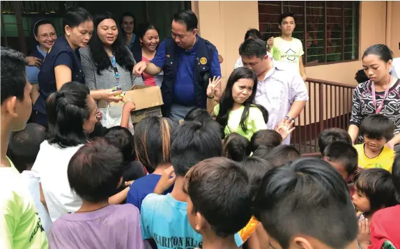  ?? LUCKY P. MALICAY ?? Members of Rotary Club of Metro Cebu District 3860 distribute goodies and gift packs to poor families at the Balay Samaritano in Cebu City yesterday.