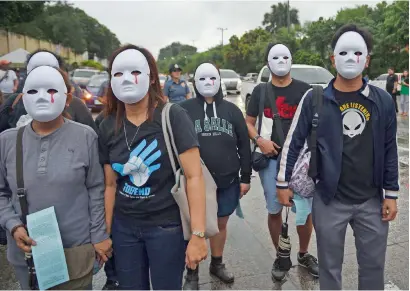  ?? AFP ?? Protesters wearing masks depicting victims of extra judicial killings taking part in a demonstrat­ion against the killings of suspected drug users allegedly by police during anti-drugs raids in Manila —