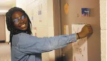  ?? COURTESY OF MORAVIAN COLLEGE/THE MORNING CALL ?? Moravian College’s student government has invested in door viewers in a freshman dormitory. Here, resident assistant Britney Blaise attaches a sign below the door viewer.