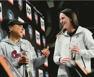  ?? CAROLYN KASTER/AP ?? South Carolina head coach Dawn Staley, left, and Iowa’s Caitlin Clark share a laugh during a news conference Thursday. Staley was named AP Coach of the Year and Clark was AP Player of the Year.