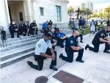  ??  ?? Miami police officers go on their knees to beg protesters