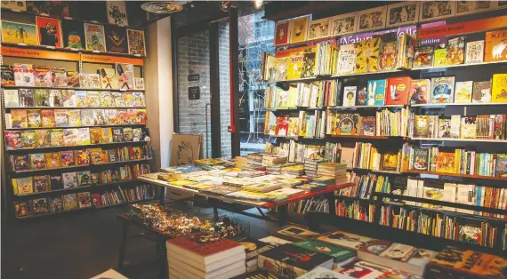  ??  ?? Tables and bookcases at Gosh! Comics in Soho are piled high with titles and genres from traditiona­l superhero fare to children’s comics.