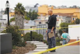  ?? Leah Millis / The Chronicle ?? A law enforcemen­t officer investigat­es an area near the scene of a shooting involving multiple people at Dolores Park. The gunfire wounded two men and a boy.