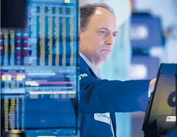  ?? ALLIE JOSEPH/NEW YORK STOCK EXCHANGE ?? James Conti, a trader, works the floor Friday of New York Stock Exchange. The S&P 500 index was down 2.3% for the day before a late rally.