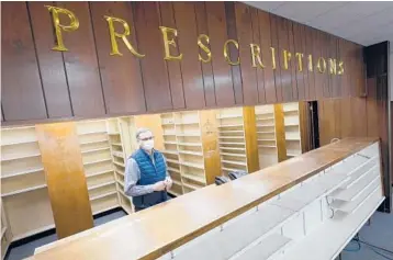  ?? STEVE HELBER/AP ?? Retired pharmacist Russell Alan Garner stands in his empty store Feb. 9 in Wakefield, Virginia. Getting the vaccine has been a challenge for rural counties that lack medical facilities such as a pharmacy or well-equipped doctor’s office.