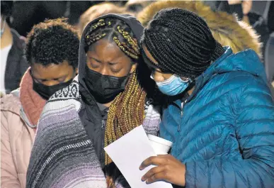  ?? MARY COMPTON/DAILY SOUTHTOWN ?? Jhene Purry and Janiya Richardson bow their heads as they remember Justin Young during the vigil.