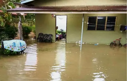  ??  ?? Water all around: Torrential rain since early yesterday has left several houses and village roads in Kampung Kilan, Labuan submerged in water. — Bernama