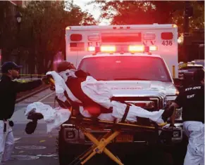  ?? (Photo by Mark Lennihan, AP) ?? Emergency personnel transport a man on a stretcher after a motorist drove onto a busy bicycle path near the World Trade Center memorial and struck several people Tuesday in New York.