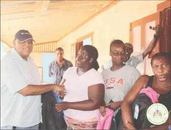  ?? (Ministry of supplies Natural Resources photo) ?? Minister Raphael Trotman (left) handing out school