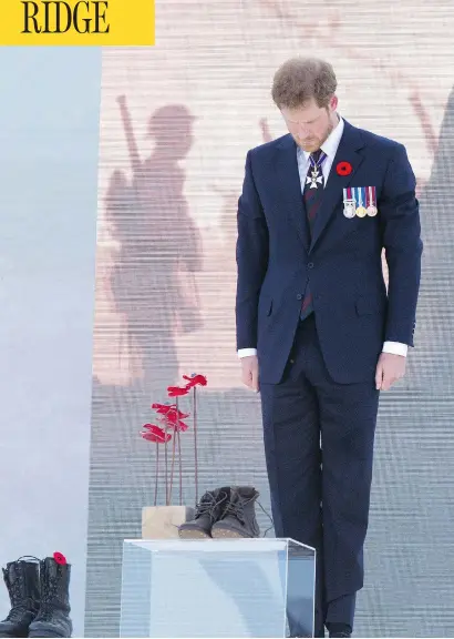  ?? ANDY COMMINS, POOL / GETTY IMAGES ?? Prince Harry contemplat­es a sculpture of poppies by artist Bernard Freseau and soldiers’ boots at the Vimy commemorat­ion on Sunday. The Vimy monument records the names of 11,285 Canadians who died in France and whose bodies were never found.