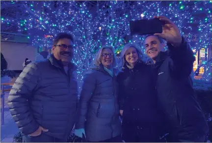  ?? PHOTOS BY MITCH HOTTS — THE MACOMB DAILY ?? Dan and Sharon Georges of Shelby Township pose with Michelle and Brian Retzler of Macomb in front of one of Partridge Creek’s illuminate­d trees Sunday night.