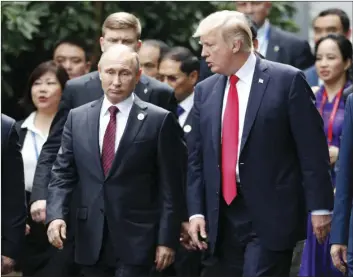  ??  ?? U.S. President Donald Trump (right) and Russia’s President Vladimir Putin talk during the family photo session at the APEC Summit in Danang, Vietnam on Saturday. JORGE SILVA/POOL PHOTO VIA AP