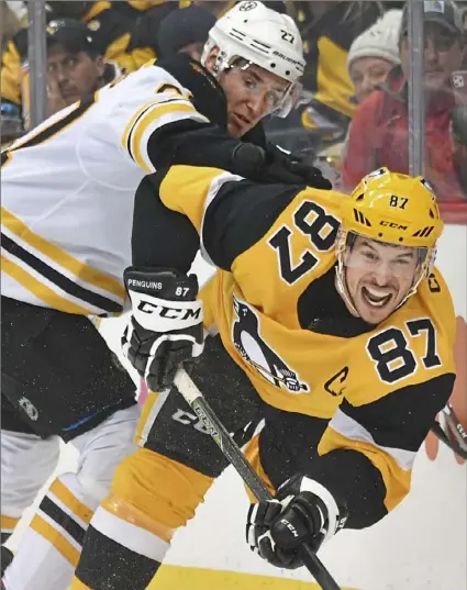  ?? Peter Diana/Post-Gazette ?? Sidney Crosby takes a big hit from Bruins defenseman John Moore Sunday at PPG Paints Arena. Crosby had two assists and now has eight points in four games since returning to the lineup.