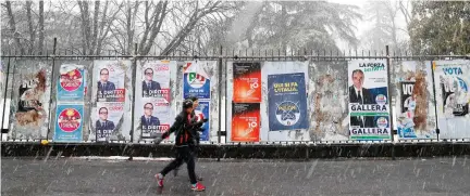  ??  ?? Two women walk past electoral posters for Italy’s general elections, in Milan on Saturday. (AP)