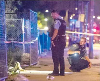  ?? TYLER LARIVIERE/SUN-TIMES ?? Chicago police officers investigat­e the scene where multiple people were shot on Sunday.