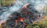  ??  ?? Lava flow burns vegetation near the town of Pahoa on the Big Island of Hawaii. The Hawaii National Guard is deploying troops to a rural Hawaii town as lava makes a slow crawl toward a major road and threatens to further isolate the community that got...