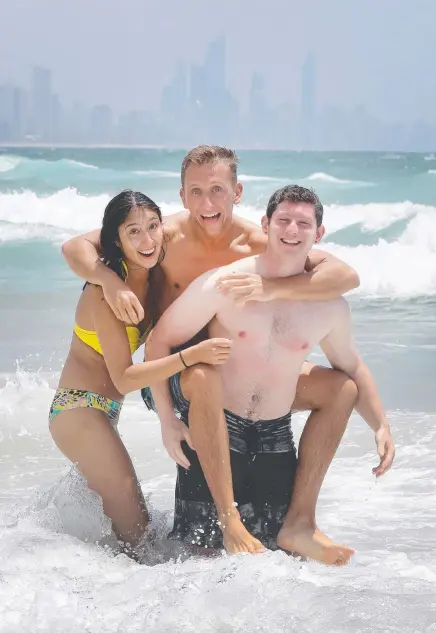  ?? Picture: GLENN HAMPSON ?? Tyler Jeske (centre) is dodging freezing conditions at home in Wisconsin by hitting the waves at Burleigh Heads to soak up the warm Gold Coast weather with friends Zack Shapiro and Amanda Slim, who is from the Netherland­s.