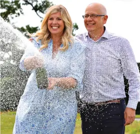  ?? ?? Family fortune: The couple pop open champagne to celebrate