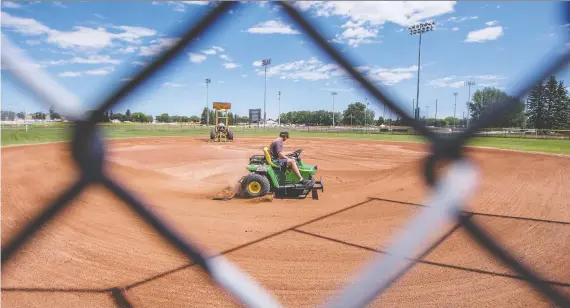  ?? LIAM RICHARDS ?? Workers groom the infield at Glen Reeve Field Diamond No. 5 at the Gordie Howe Sports Complex. City baseball and softball leagues returned to action on Monday night.