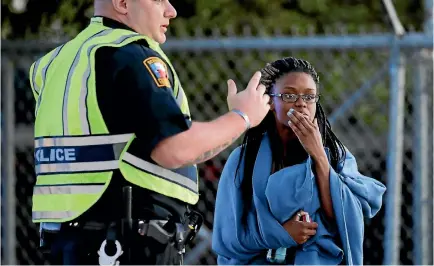  ?? PHOTO: AP ?? An employee talks to a police officer after she was evacuated at a FedEx distributi­on centre where a package exploded yesterday in Schertz, Texas.