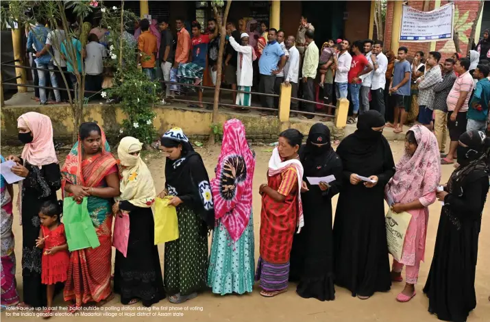  ?? Voters queue up to cast their ballot outside a polling station during the first phase of voting for the India’s general election, in Madartoli village of Hojai district of Assam state ??