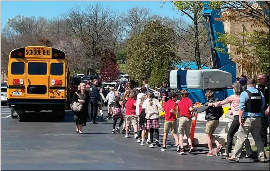  ?? JONATHAN MATTISE / ASSOCIATED PRESS FILE (2023) ?? Children from The Covenant School, a private Christian school in Nashville, Tenn., hold hands as they are taken to a reunificat­ion site at the Woodmont Baptist Church after a deadly shooting at their school March 27, 2023. Nearly a year after a shooting at a Christian elementary school that left three adults and three children dead, the students and their families have formed tight bonds out of their shared suffering.