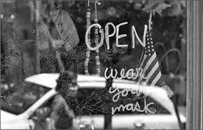  ??  ?? ‘We zijn open, maar zet je mondkapje op’, meldt deze winkel in San Francisco. (Foto: De Telegraaf)