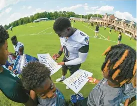  ?? KEVIN RICHARDSON/BALTIMORE SUN ?? Ravens linebacker Roquan Smith signs autographs for fans on the first day of training camp Wednesday.