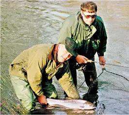  ??  ?? Vigfússon in 1999 returning an 8lb salmon to the river Camel, Cornwall, watched by Stephen Barnes