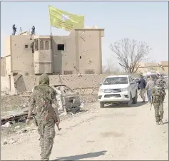  ??  ?? A Syrian Democratic corces flag flutters on a damaged building in the village of BaghouzK — oeuters photo