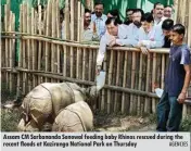  ??  ?? Assam CM Sarbananda Sonowal feeding baby Rhinos rescued during the recent floods at Kaziranga National Park on Thursday