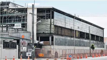  ?? PHOTOS: STEPHEN JAQUIERY ?? Rail reno . . . Contractor­s (top and above) wearing protective clothing and breathing apparatus remove cladding from the Hillside workshop building in South Dunedin.