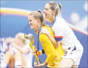  ?? Elsa / Getty Images ?? Alyssa Naeher and Morgan Brian, right, celebrate with the FIFAWomen’sWorld Cup Trophy following their team’s win over the Netherland­s on Sunday in Lyon, France.