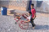  ?? MARKO DROBNJAKOV­IC/ASSOCIATED PRESS ?? Two boys play in a camp for displaced people on the outskirts of Irbil in Iraq on Tuesday. Nearby Mosil is the largest city controlled by the Islamic State group.