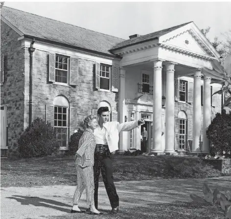  ?? FOTO: AP ?? Elvis Presley steht im Jahr 1957 mit seiner Freundin Yvonne Lime vor seinem neuen Heim in Memphis. Am 10. März 1957 unterzeich­nete er den Kaufvertra­g für Graceland: Das Anwesen und 5,7 Hektar Grundstück kosteten 100.000 Dollar.