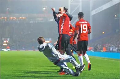  ?? PHIL NOBLE / REUTERS ?? Zlatan Ibrahimovi­c celebrates with some pitch-invading fans after scoring Manchester United’s winner in Sunday’s 2-1 FA Cup fifthround victory over Blackburn Rovers at Ewood Park, Blackburn.