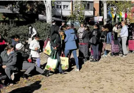  ?? ?? DESPERATIO­N People line up to get food donated by sponsors and given away by a civic welfare group in the Spanish capital.