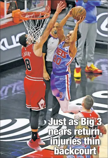  ?? AP ?? SUCH A SHAME: Nets guard Landry Shamet (right), who limped off the court in the fourth quarter, shoots over the Bulls’ Zach LaVine during the second half of Sunday’s loss in Chicago.