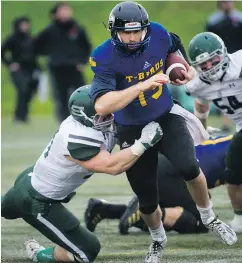  ??  ?? The T-Birds’ Michael O’Connor is tackled by the Huskies’ Riley Pickett in Saturday’s Hardy Cup semifinal.