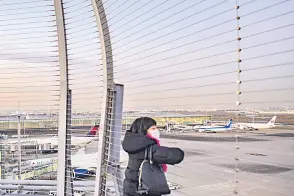  ?? — AFP photo ?? A woman looks on from the observatio­n deck of Tokyo’s Haneda internatio­nal airport, as Japan announced plans to bar all new foreign travellers over the Omicron variant of Covid-19.