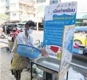  ?? VARUTH HIRUNYATHE­B ?? A man washes his hands at a sink at Pak Khlong Talat flower market.