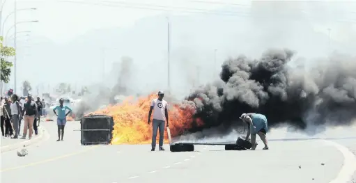  ?? PICTURE: HENK KRUGER ?? BURNING ISSUE: Angry residents block the road with burning tyres along Japhta K Masemola Road in Khayelitsh­a. According to Metro Police, people occupying the land illegally are unhappy about their informal structures being broken down.