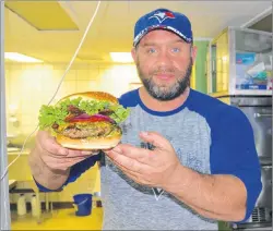  ?? JEREMY FRASER PHOTOS/CAPE BRETON POST ?? James Donato, co-owner of Commercial Street Deli in North Sydney, is shown holding his special bacon jalapeño burger, created for this year’s Bartown Burger Battle event. The Bartown Burger Battle runs until Sunday.